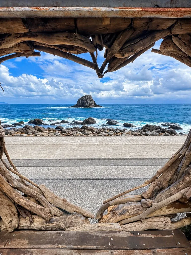 透過漂流木愛心框看見海岸與礁石
